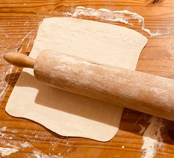 istock Rolling the dough on a wooden table 1353474784