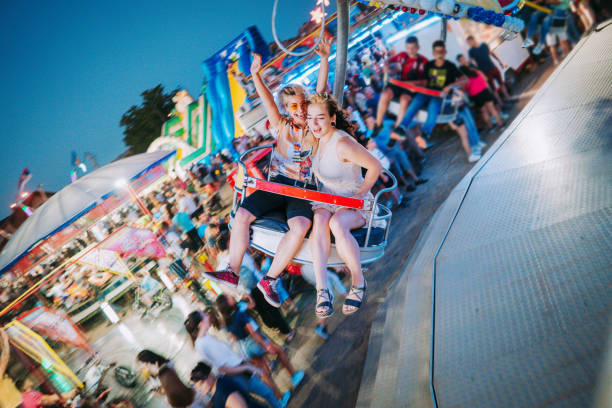 Happy young couple on carousel in amusement park