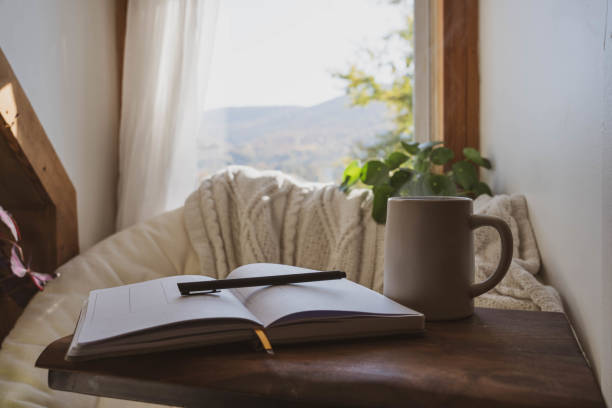 Cozy Window Nook with Open Journal And Coffee A cozy mental health break with an open journal, pen and coffee cup. mindfulness stock pictures, royalty-free photos & images