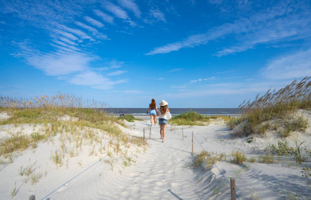 istock Girls walking on the beautiful white sand beach. 1353478016