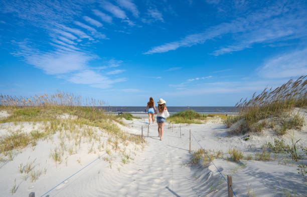 dziewczyny spacerując po pięknej piaszczystej plaży. - jekyll island zdjęcia i obrazy z banku zdjęć