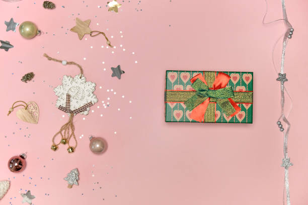 istock Top view of a Christmas gift with a bow. Pink background. 1353478122