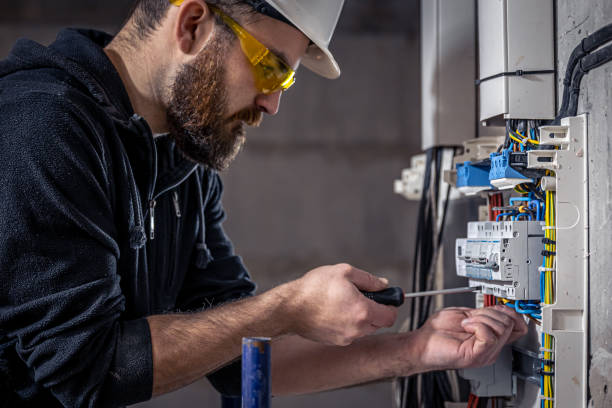 istock A male electrician works in a switchboard with an electrical connecting cable. 1353480190