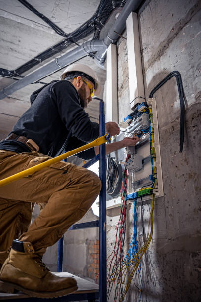 istock A male electrician works in a switchboard with an electrical connecting cable. 1353480194