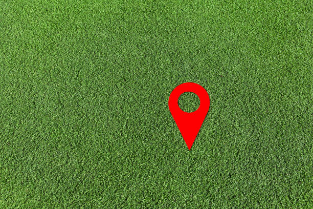 istock Red geo locate symbol on green lawn. Design element. Artificial green grass. Empty space 1353480250