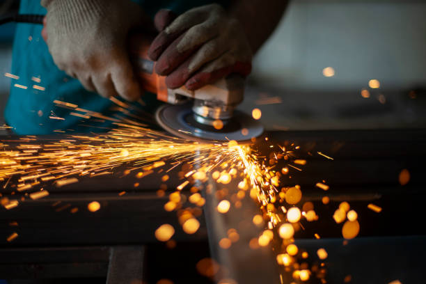 Metal cutting. Grinding steel. Work as a grinder. Metal cutting. Grinding steel. Work as a grinder. Sparks from friction. Men's work. Creating a design. The project in the workshop. Iron processing. Hand electric tool. steel grinding stock pictures, royalty-free photos & images