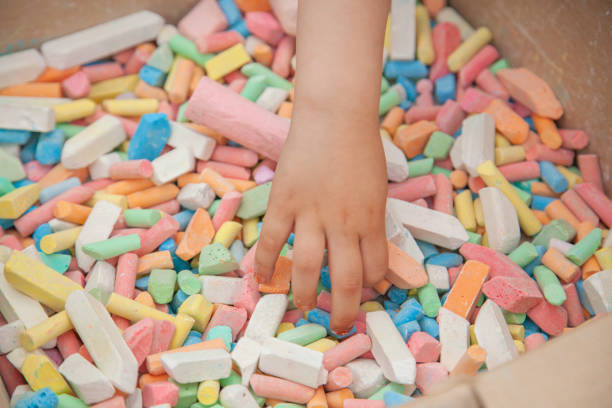 istock Crayes for drawing. Child takes chalk. Hand reaches for colored crayons for drawing. 1353482203