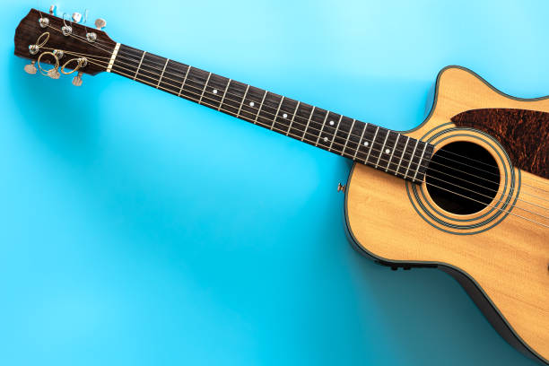 istock Acoustic guitar on a blue background, top view, copy space. 1353482270