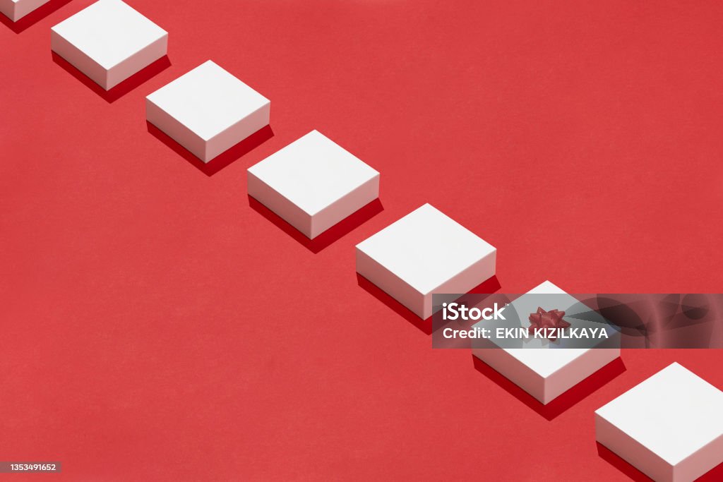 White gift boxes in a row on red background In A Row Stock Photo