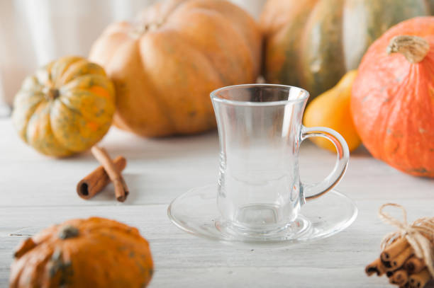 istock Empty cup on background of pumpkins. Pumpkin autumn warming drink close-up and copy space.. 1353491949