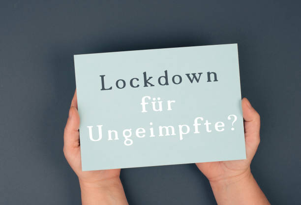 istock Lockdown for unvaccinated is standing in german language on the paper, covid-19 regulations, anti vaccine 1353497516