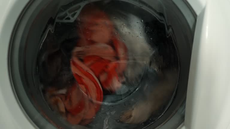 Close-up of colored things and wash towels in the washing machine