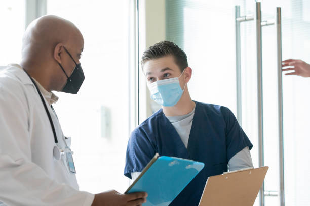 istock Surgeon and nurse reading medical chart together 1353503825