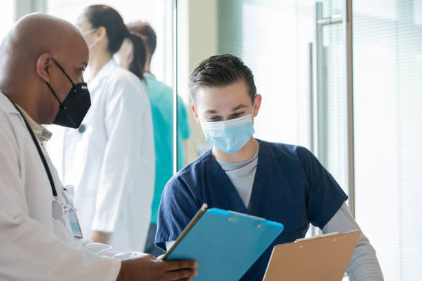 istock Surgeon and nurse reading patient chart together 1353503840