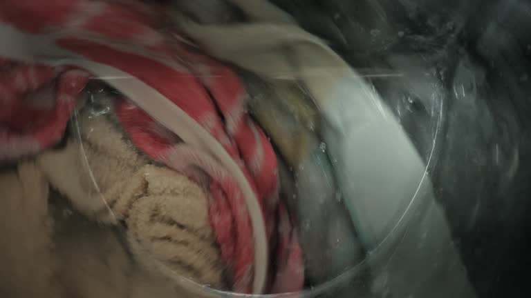 Close-up of colored things and wash towels in the washing machine