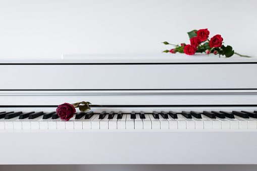A bouquet of flowers lies on the piano with the keys open. Learning music, gratitude.