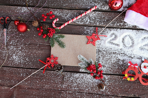 Fir tree, gift boxes, scissors, rope, cocoa with marshmallow and blank sheet of paper on a wooden background. Christmas and New Year decorations.