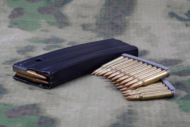 5.56mm ammunition with full metal jacket bullet with magazine on camouflage uniform - full metal jacket imagens e fotografias de stock