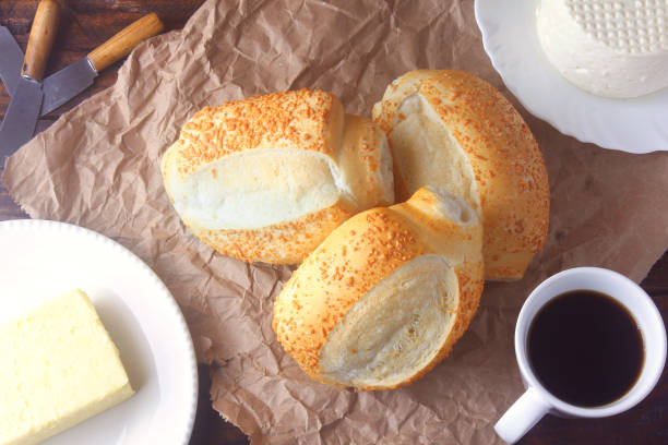 istock Brazilian French bread, on rustic paper, on rustic wooden table for breakfast. 1353506677