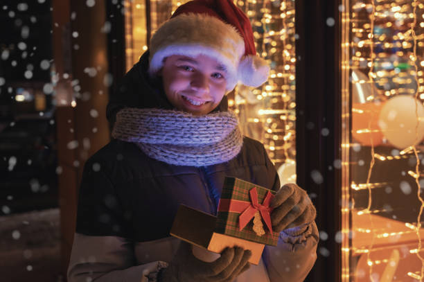 istock Boy in Santas hat with gifts box looking and dreaming 1353509546