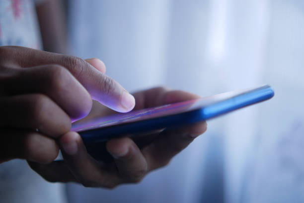 istock child hand pointing finger on smart phone screen. 1353519678