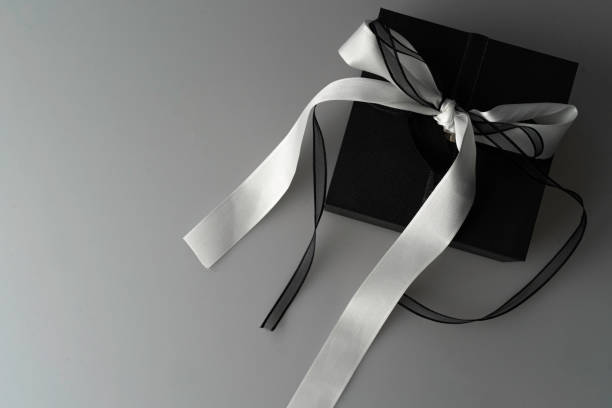 istock Black gift box, with black and white bun on a white background. Overhead shot 1353520710