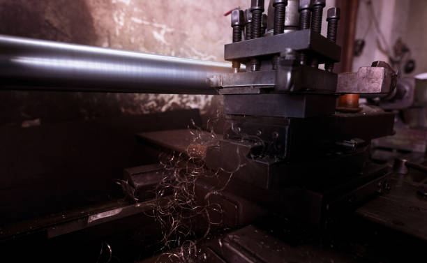 Lathe machine working in factory. Lathe turning machine for metalwork. Heavy machinery manufacturing. Machine for milling metal. Manual lathe machine. Safety in industrial workplace. Steel industry. máquina de torno que trabaja en fábrica. máquina de torneado de torno para carpintería metálica. fabricación de maquinaria pesada. máquina para fresado de metal. máquina de torno manual. seguridad en el lugar de trabajo industrial. industria sider�