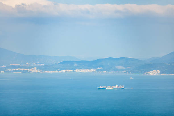 Cargo Container Ship on the sea near the coast and mountains, hong kong, daytime