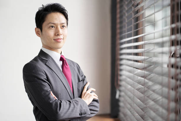 istock Asian businessman standing by the window 1353531148