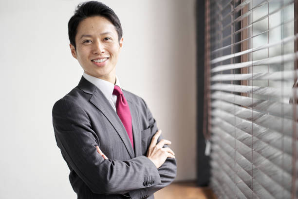 窓のそばに立つアジアの実業家 - 男 ストックフォトと画像
