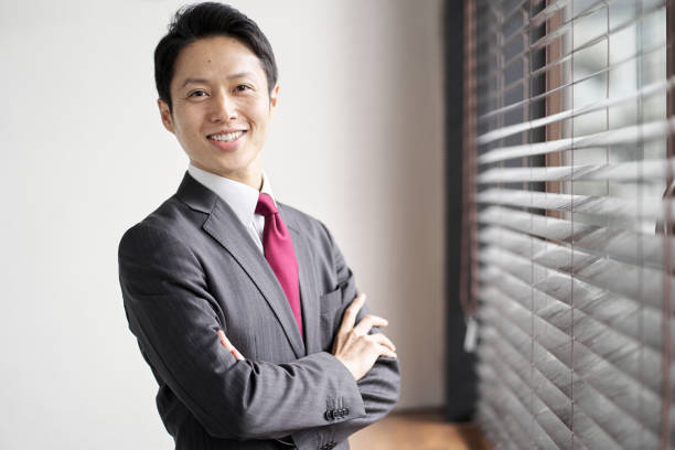 istock Asian businessman standing by the window 1353531169