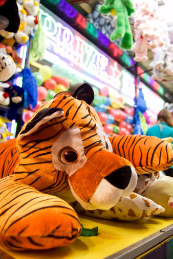 colorful close up photograph of a toy stuffed tiger prize to be won from playing a balloon carnival game