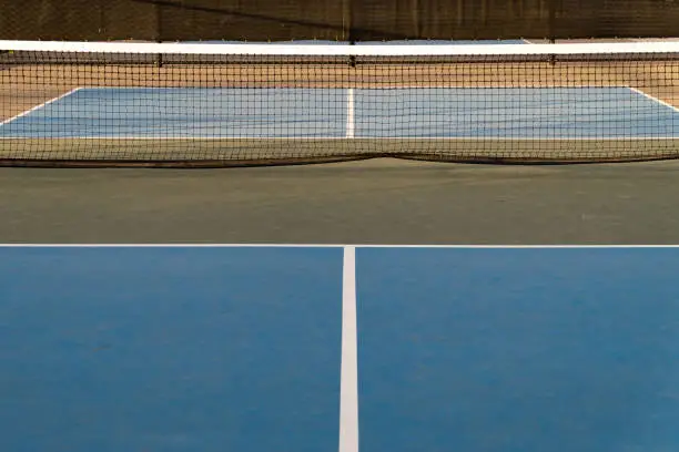 Various angles of pickleball courts showing the net, surface and facility.  Pickleball is a popular activity with younger generations.