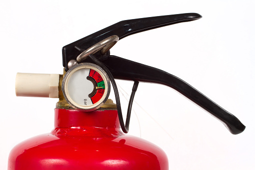 Fire extinguisher details close-up. Spray element of fire extinguisher with pressure gauge.