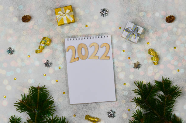 istock notepad with christmas or new year decoration, template and blank paper with copy space text, business mock up, festive background for plans, goals and resolution 1353542115