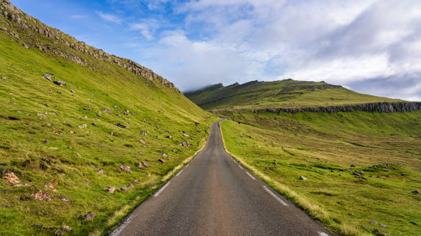Lonely Country Road Panorama Eysturoy Island Faroe Islands Lonely Country Road through green faroese scenic landscape. Eysturoy Island, Faroe Islands, Kingdom of Denmark, Nordic Countries, Northern Europe eysturoy photos stock pictures, royalty-free photos & images