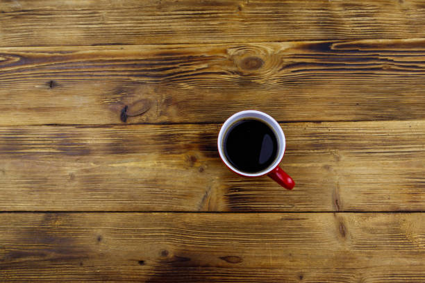 istock Cup of coffee on the wooden table. Top view, copy space 1353547164