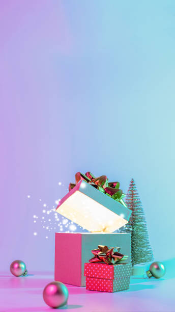 istock Neon xmas winter background. Open Christmas gift box with shine lights, minimal tree. Holiday decoration bauble ball on neon abstract gradient backdrop. Happy new year copy space. 1353547955