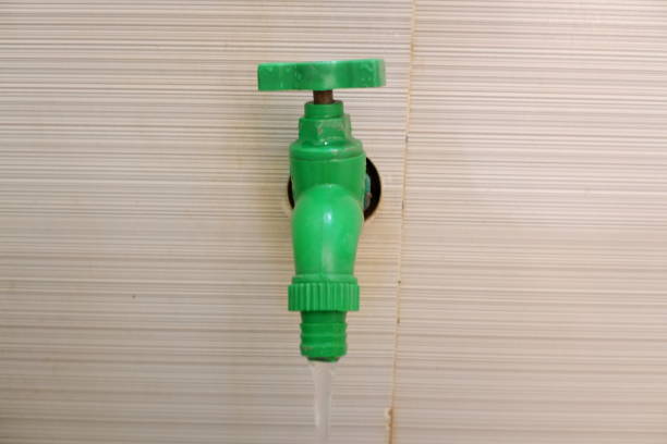 istock green faucet on the marble wall. 1353550701