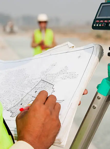 Photo of man taking measurements on theodolite