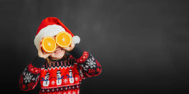 child looking at christmas present through orange on black background