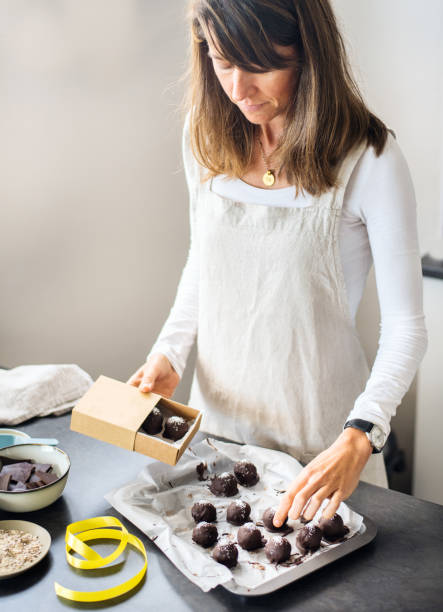 istock Young woman packaging chocolate treats for her home-based baking business 1353551555