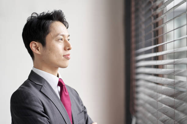 istock Asian businessman standing by the window 1353551980