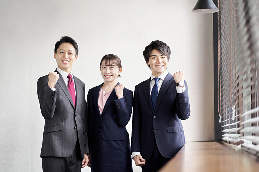 Group of happy businesspeople standing together against white background