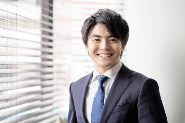empresário asiático parado perto da janela - japanese ethnicity - fotografias e filmes do acervo