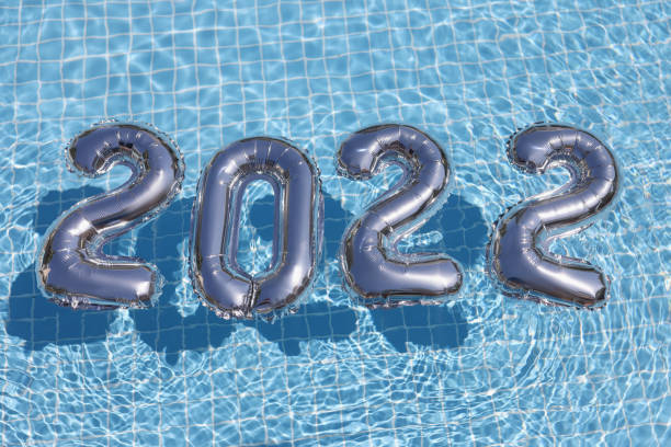 Foil silver numbers float on blue clean water of swimming pool