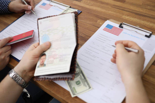 istock People filling visa application forms with personal passports at embassy 1353554459