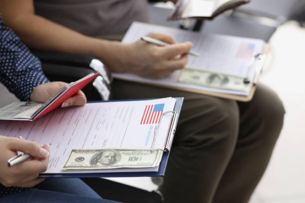 istock Men sit in line and filling visa application forms to get access to enter country 1353554471