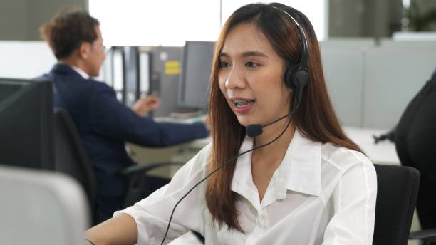 istock Call center young employee working with headset, Smiling customer support operator team at work surrounded 1353558154