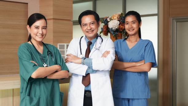 Group of modern doctors smiling standing as a team with arms crossed in hospital stock photo